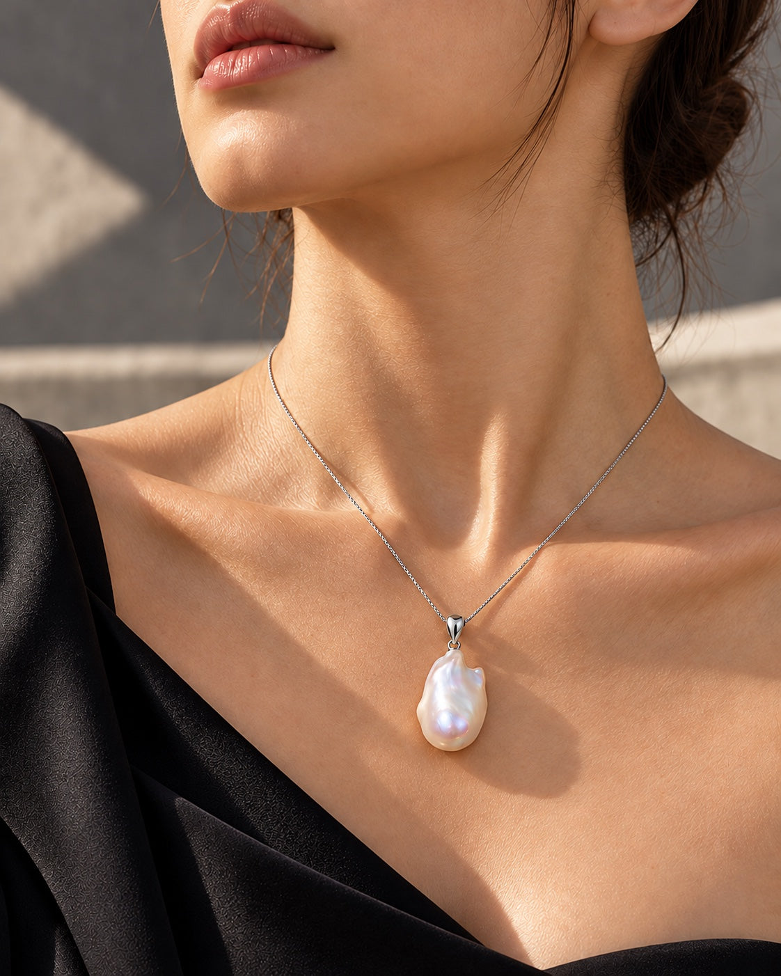 Female model wearing a natural baroque pearl necklace with a black dress